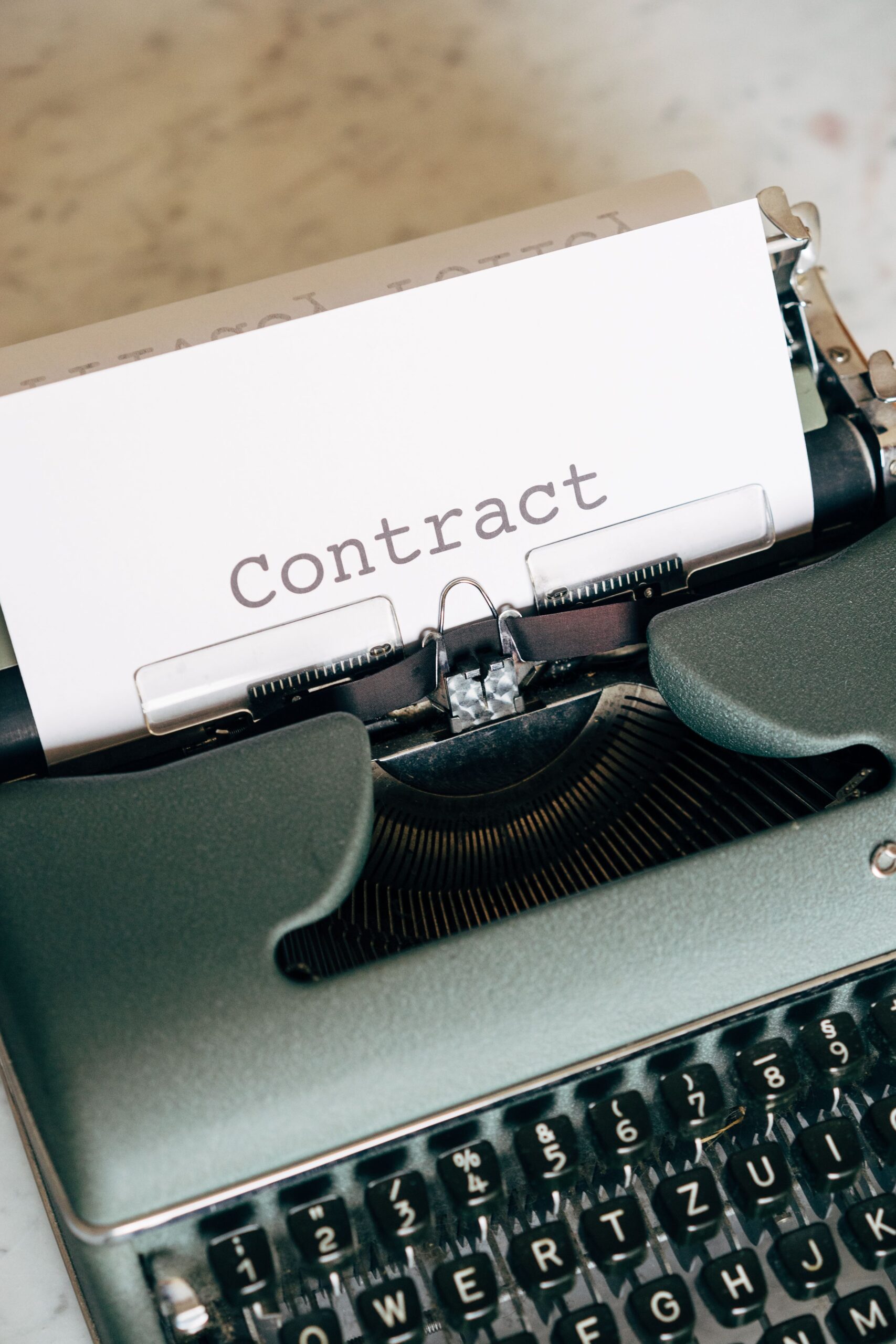 La Importancia del Contrato de Promesa de Compraventa en la Transacción Inmobiliaria Retro typewriter displaying the word 'Contract', symbolizing traditional document creation.