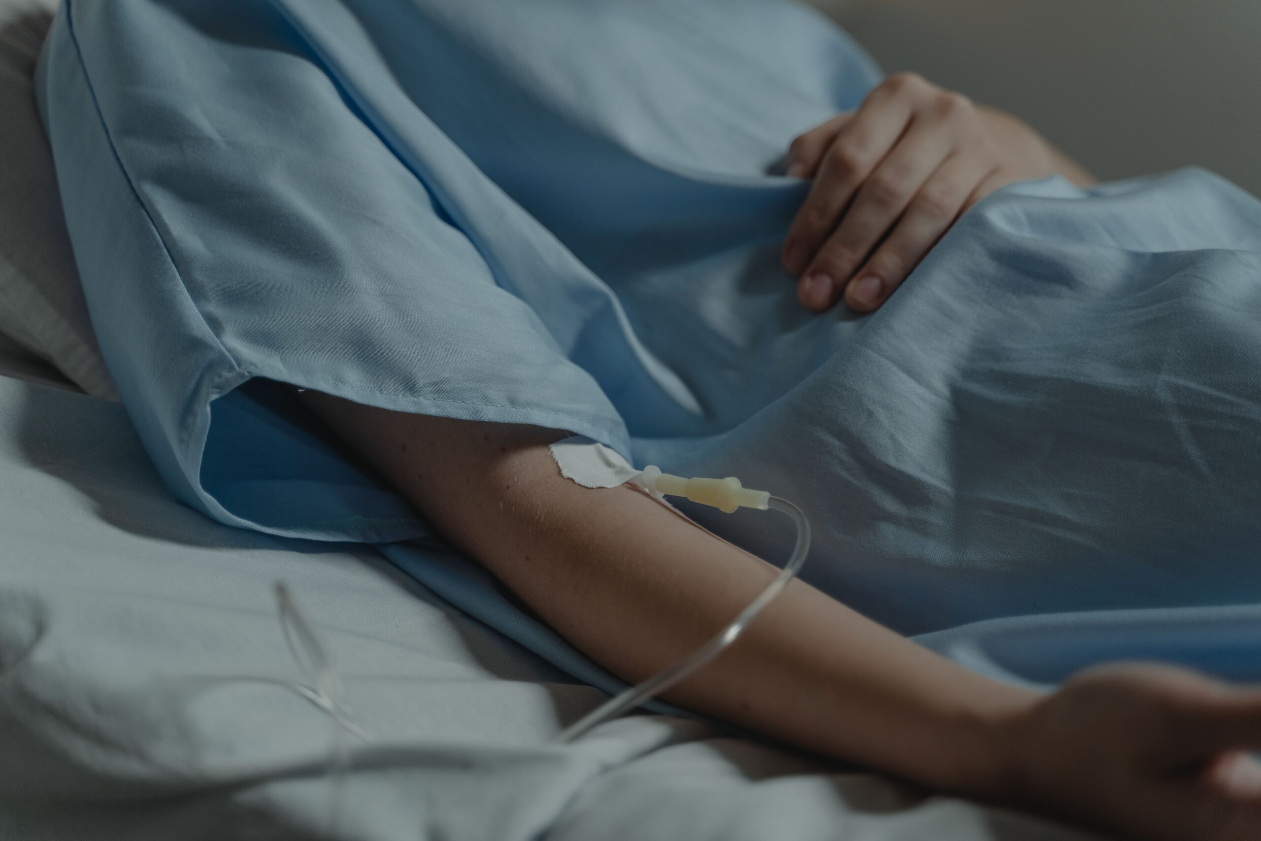 Estabilidad Laboral Reforzada Por Salud Close-up of a patient in a hospital bed with an IV drip attached to the arm.